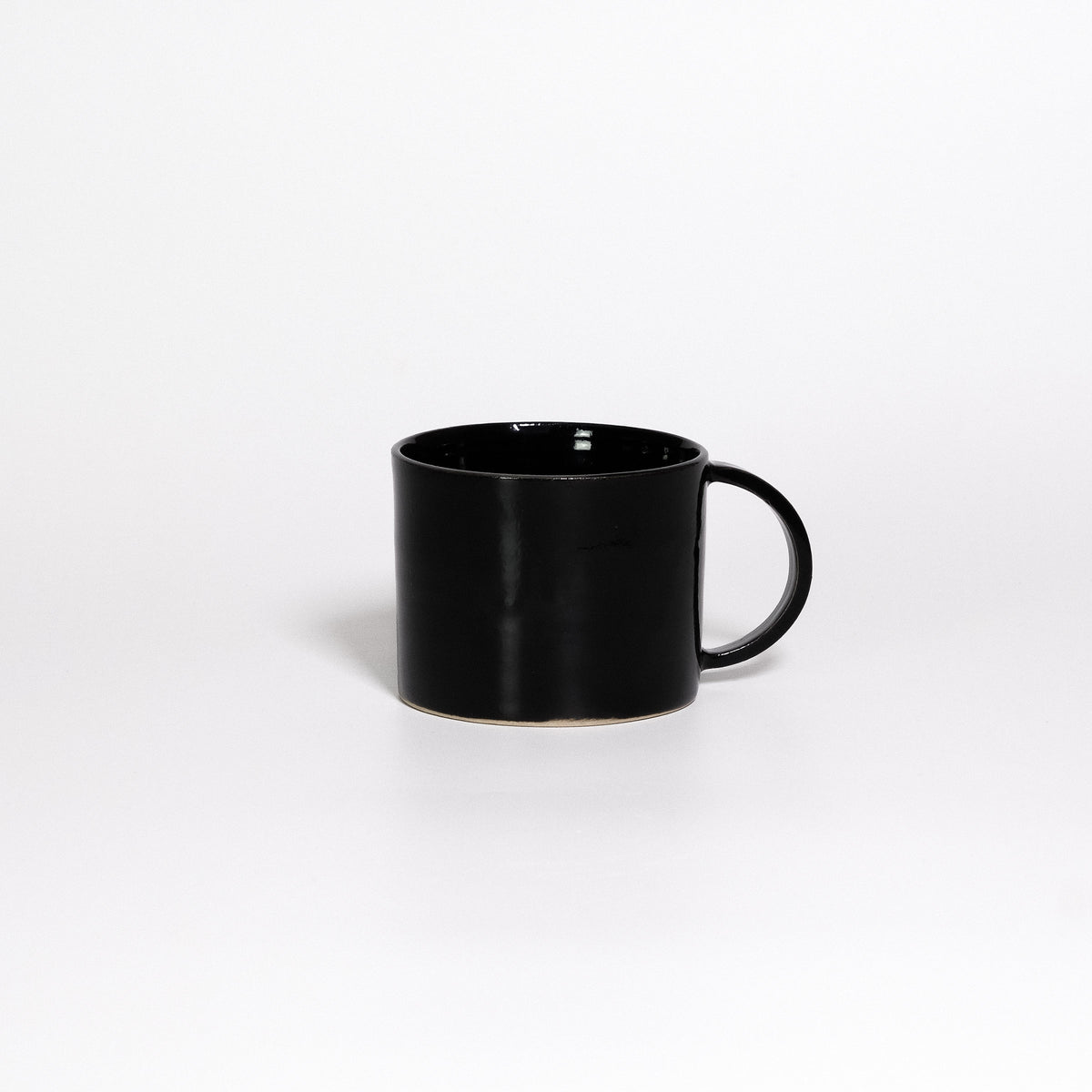 Coffee Mug Black, low wide handled stoneware mug with glossy black glaze, handle to the right