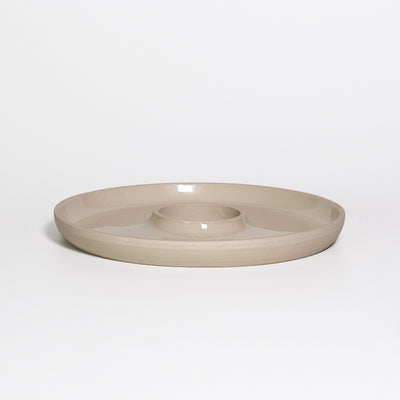 Tapas Tray Creme, round stoneware tray with a central dip well, transparent glossy glaze inside and raw clay outside