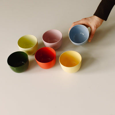 Set of 6 – Coffee Cup – Yun Mix: bunte Keramik Handgemacht Tassen auf einem Tisch, eine wird hochgehoben.