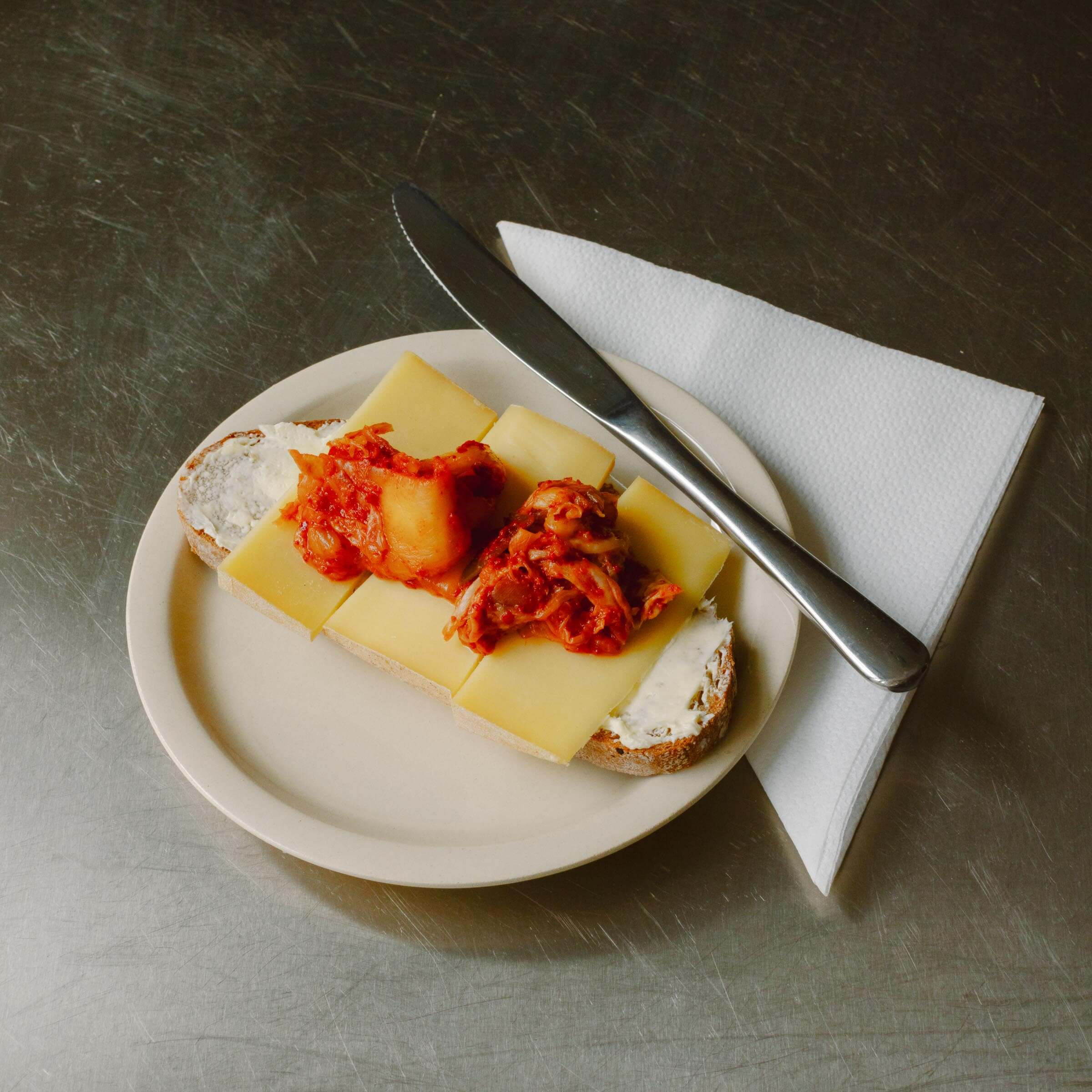 Bistro Plate - Creme featuring a slice of bread topped with cheese and savory sauce.