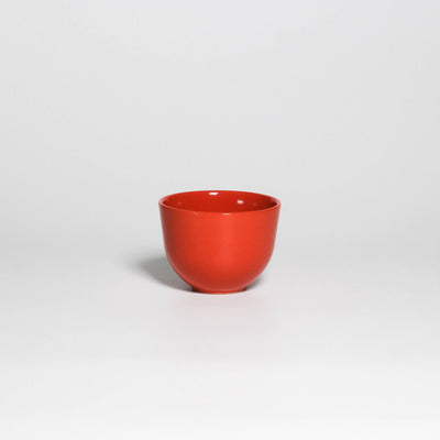Coffee Cup Yun Orange, handleless stoneware cup with glossy orange glaze, front view