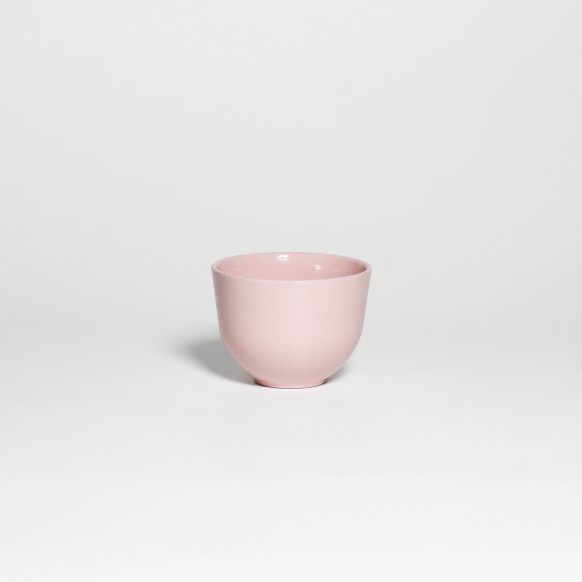 Coffee Cup Yun Pink, handleless stoneware cup with glossy soft pink glaze, front view