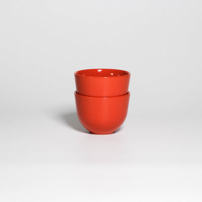 Two Coffee Cups Yun Orange stacked, handleless stoneware cups with glossy orange glaze