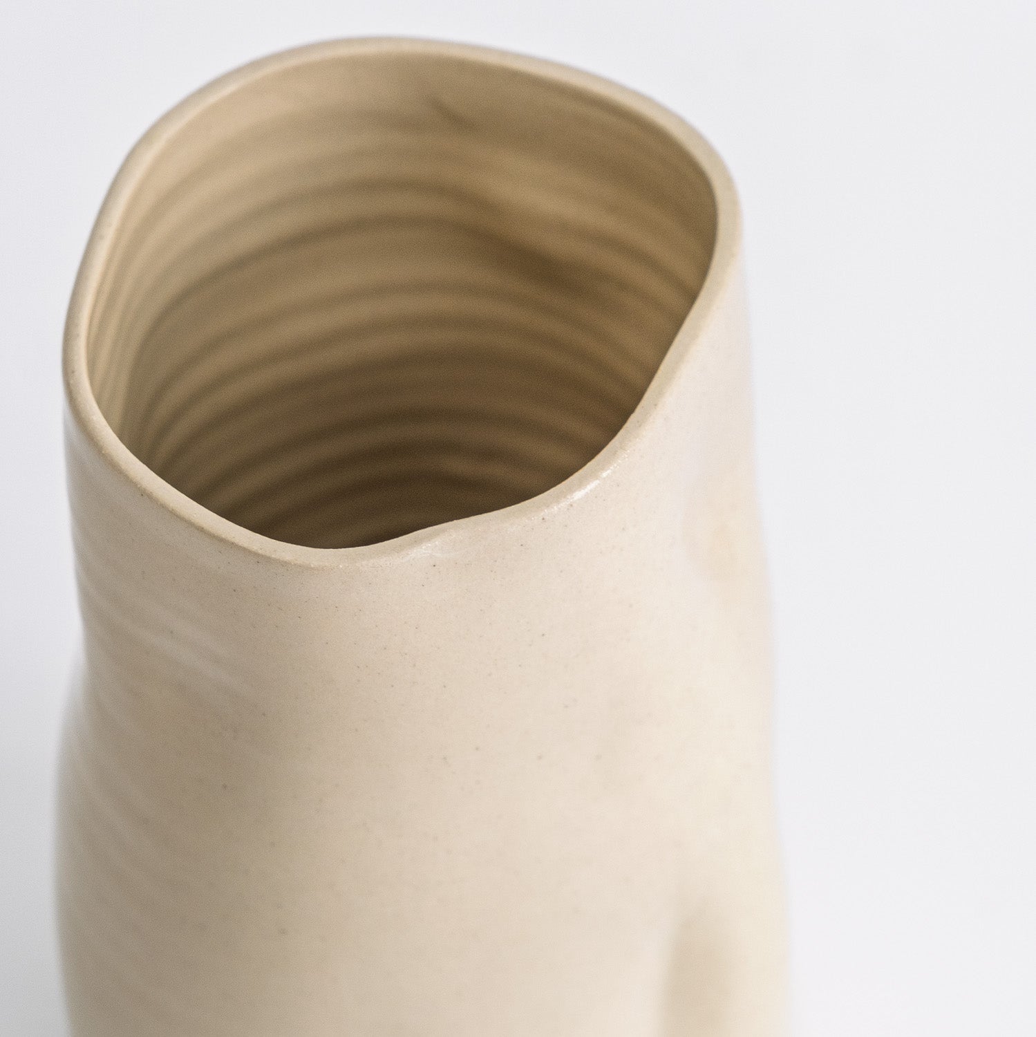 Handgefertigte creme Keramikvase – Detailaufnahme der einzigartigen Form und Glasur der Vase.