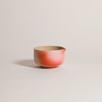 Matcha pouring bowl made of grey stoneware with pink and red gradient finish, featuring a small spout for easy pouring.