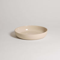 Handcrafted stoneware dinner bowl in creme color, featuring a durable and elegant design for everyday use.