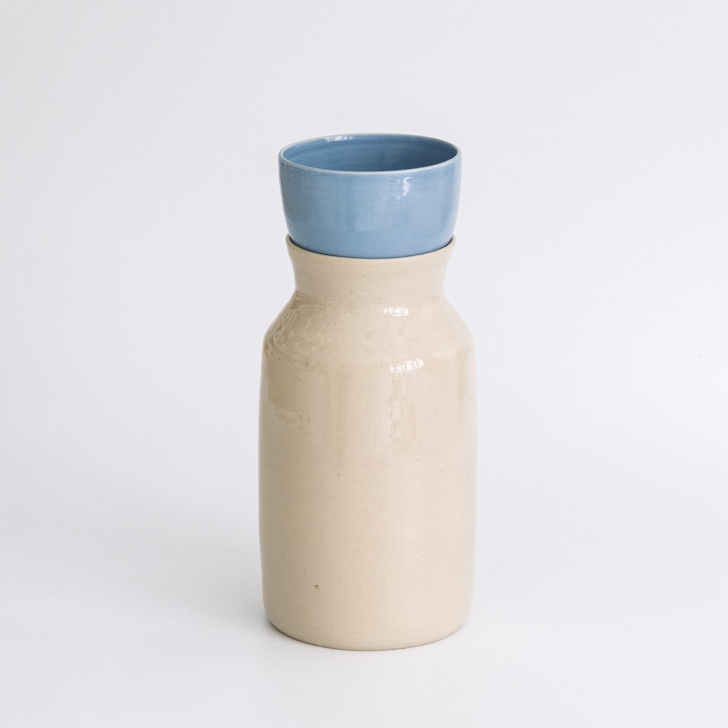 Handmade Carafe – Creme featuring a high-quality stoneware design with a warm creme glaze and a blue top.