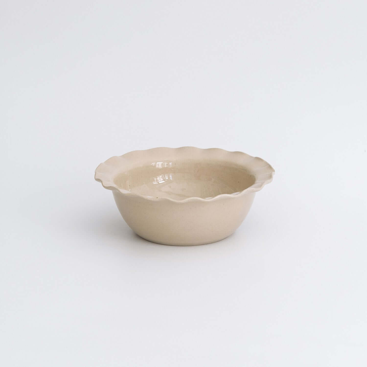 Handgemachte Keramik Frühstücksschale in Cremefarbe mit gewelltem Rand.