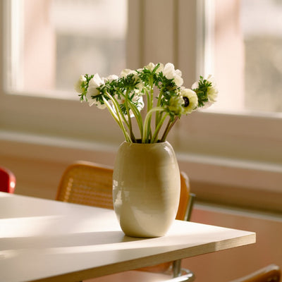 Handgemachte Keramik Blumenvase mit Blumen auf einem Tisch im Sonnenlicht.