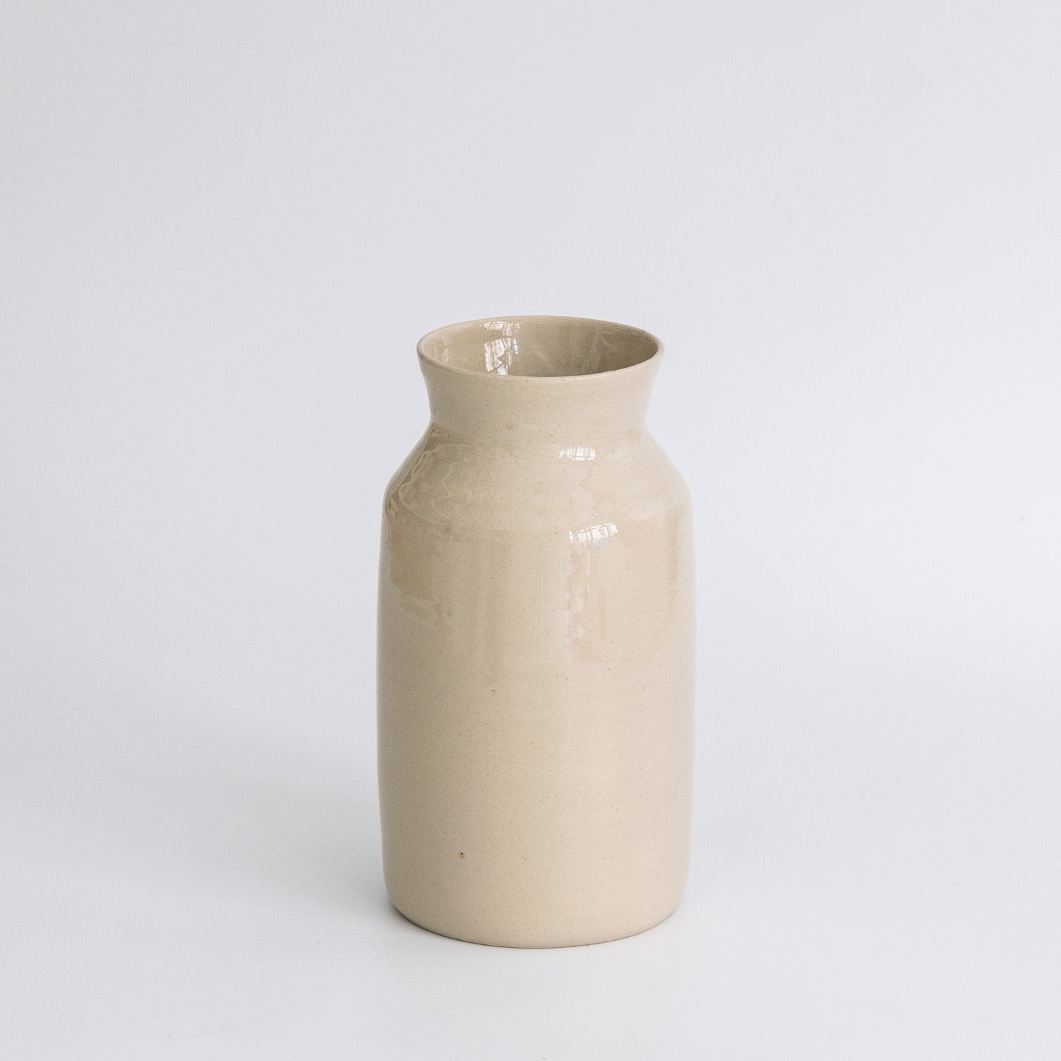 Handmade Carafe – Creme showcasing a tapered stoneware silhouette with a warm creme glaze.