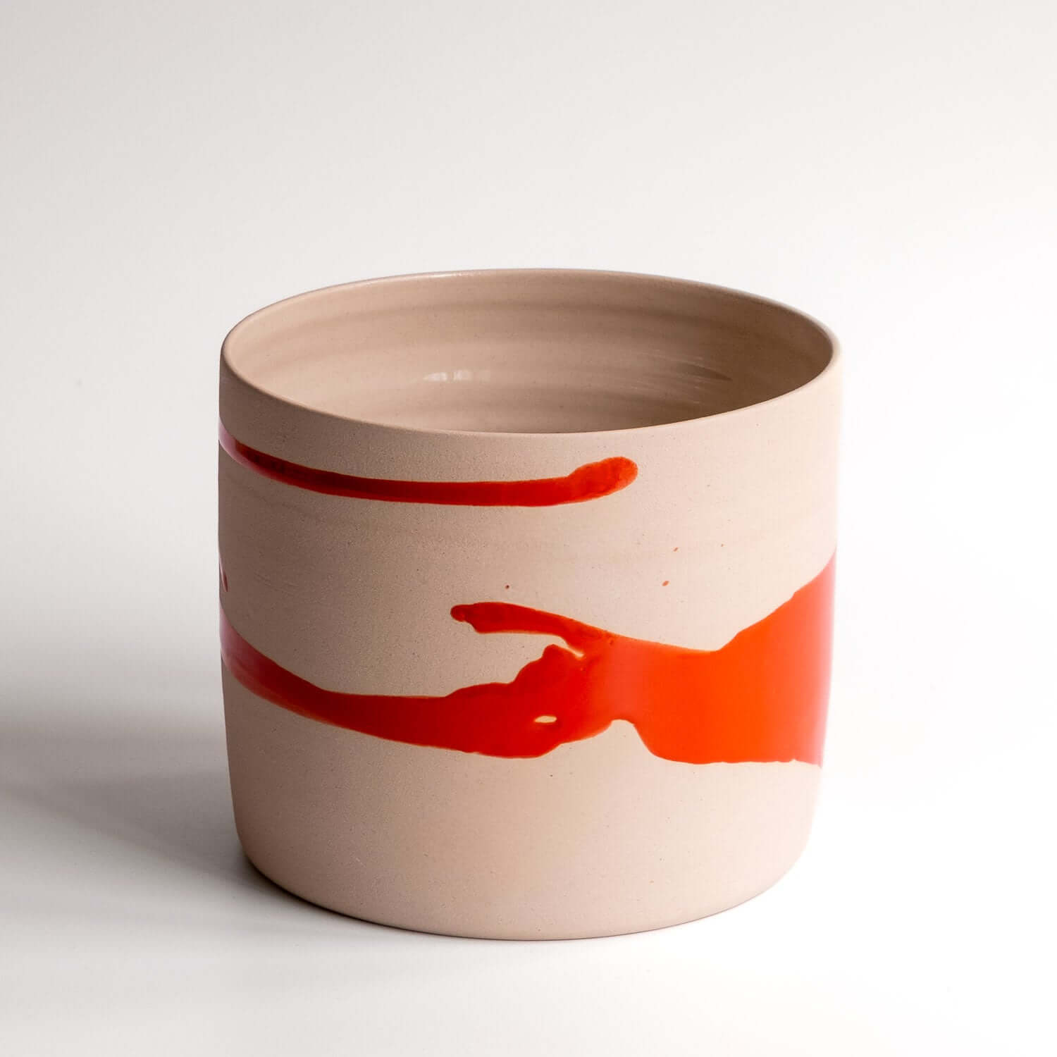 handgemachter roter Pflanzentopf mit zylindrischer Form und rotem Farbauftrag