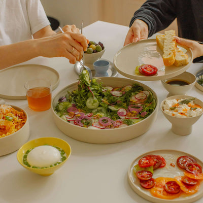 Serving Bowl – Creme mit frischem Salat und verschiedenen Gerichten auf dem Tisch, ideal für Handgemacht Keramik.