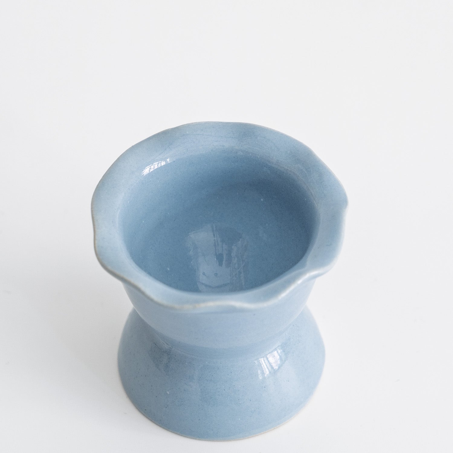 Handgemachter Eierbecher aus Steinzeug in sanftem Iceblue mit gewelltem Rand und kleinem Fuß.