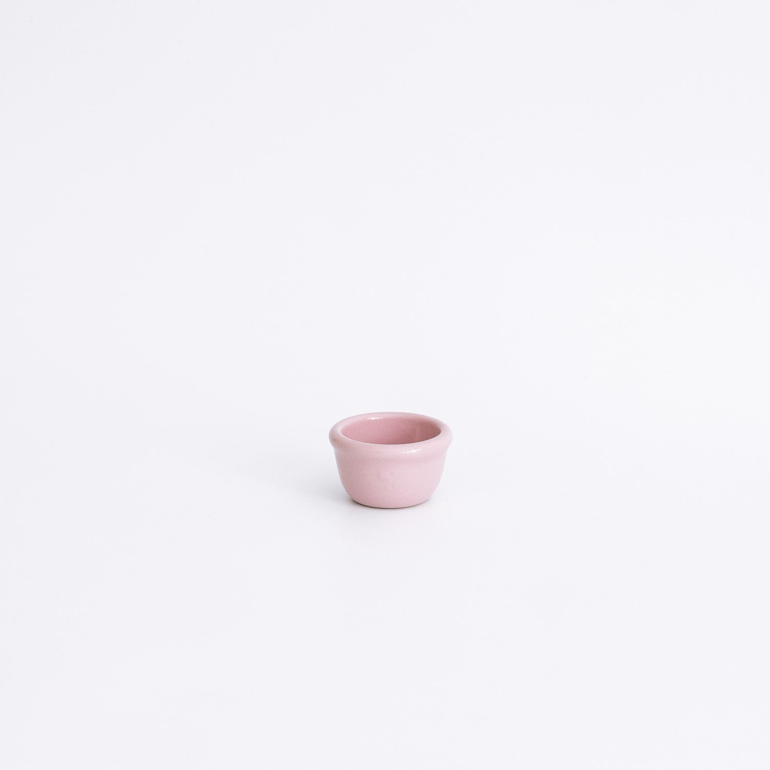 Handgemachter Eierbecher aus Steinzeug in Rosa auf weißem Hintergrund, ideal für das Frühstück.