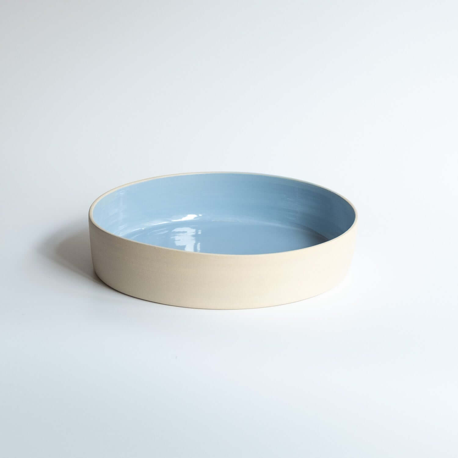 Serving Bowl - Iceblue with glossy ice blue interior and raw stoneware exterior, ideal for serving meals.