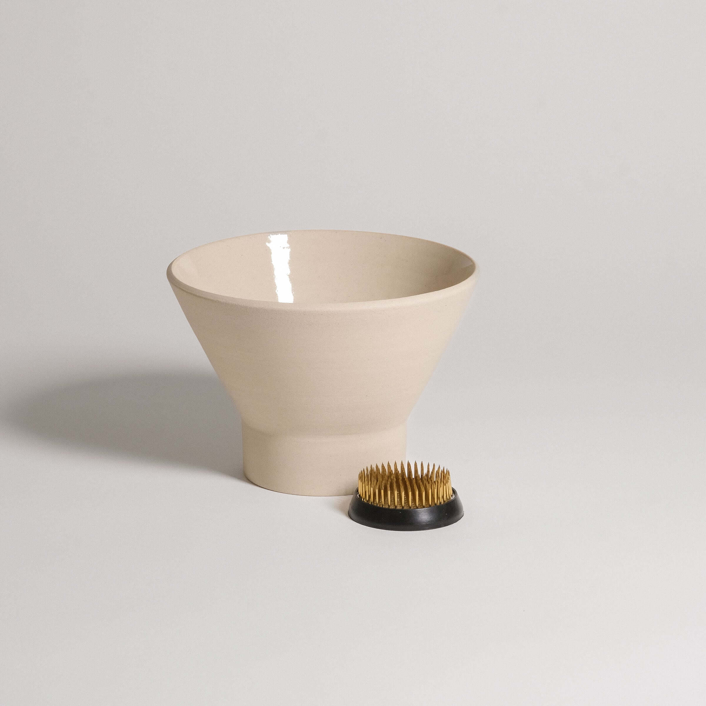 Ikebana Vase – Kenzan Set featuring a beige vase and a kenzan holder with metal spikes for flower arrangement.