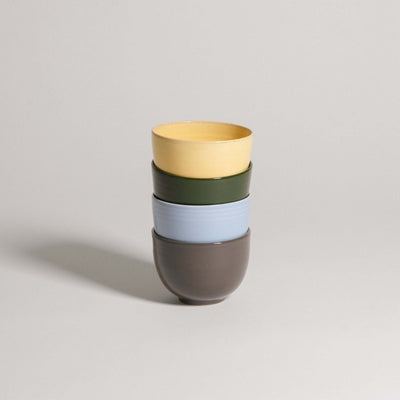 Colorful stack of cups from the Mix & Match - Cup & Mug Bundle, featuring yellow, green, blue, and brown.