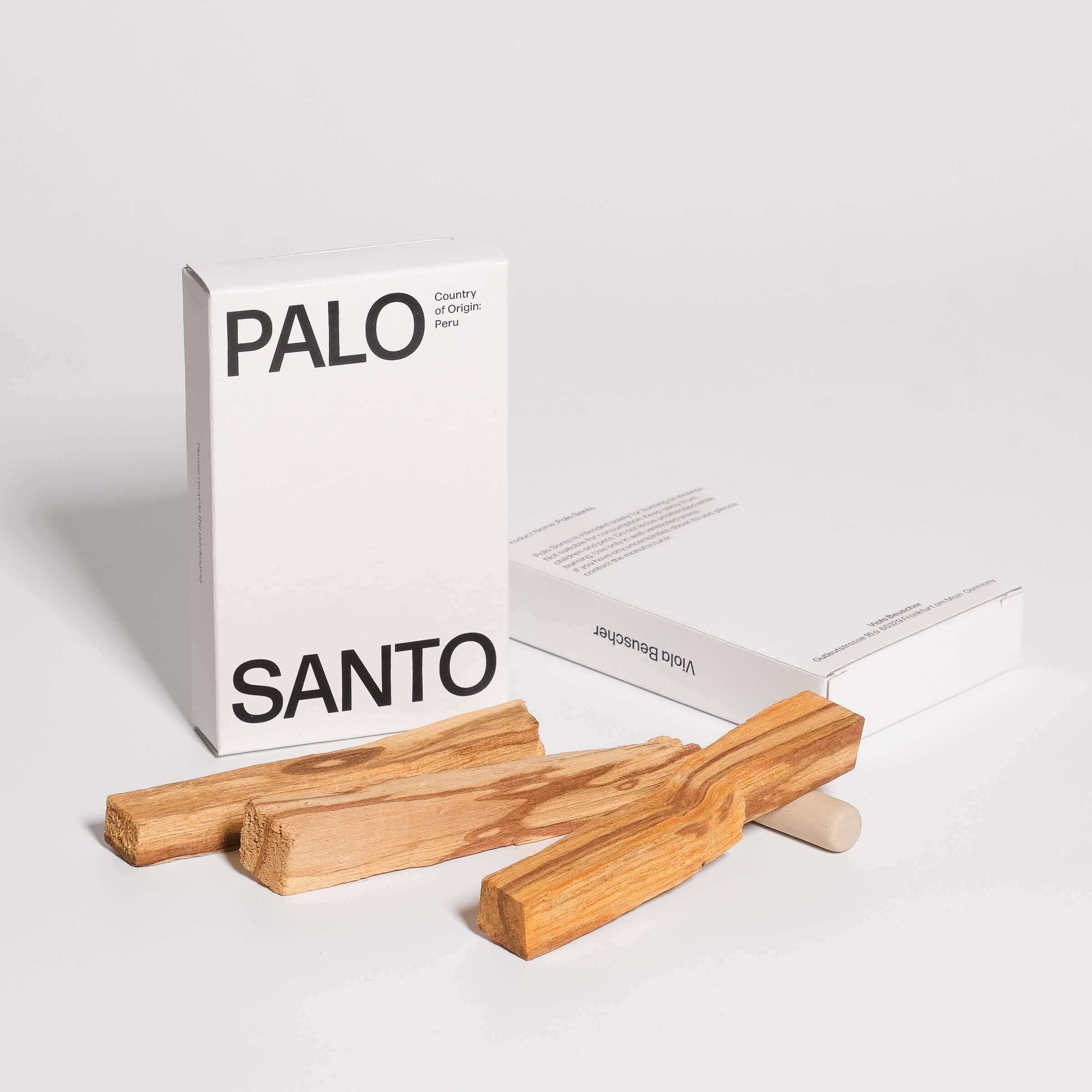 Palo Santo Set mit drei Holzstücken und einer weißen Verpackung von Palo Santo, die nachhaltige Qualität aus Peru präsentiert.
