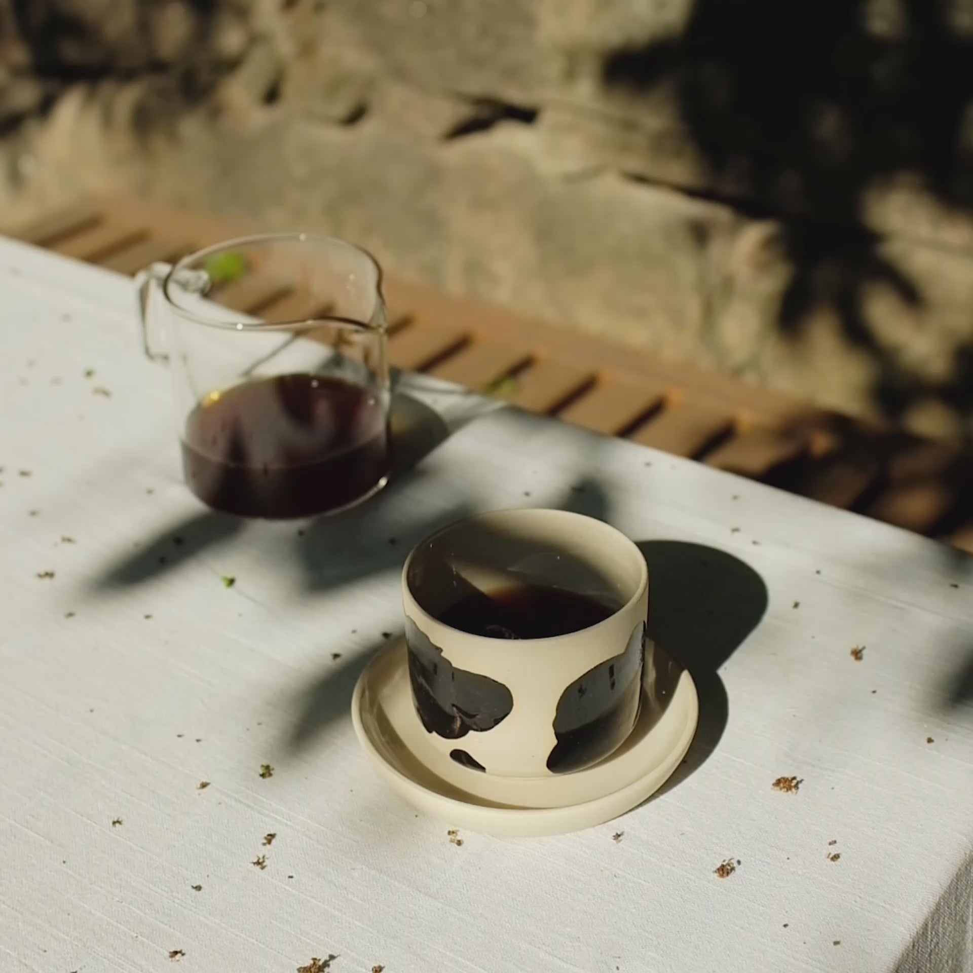 Ladda video: Set of 4 Nomi Pepe coffee cups on a table, showcasing grey stoneware with glossy black brush strokes and clear glaze.