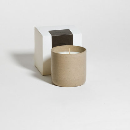 Scented Candle – Sandalwood – Amber in brown ceramic cup next to its packaging.