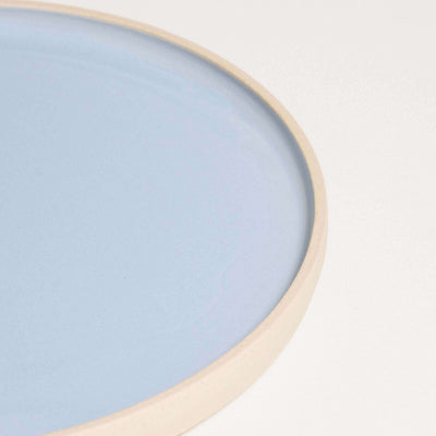 Close-up of Iceblue breakfast plate, showcasing smooth glazed interior and natural raw edge.