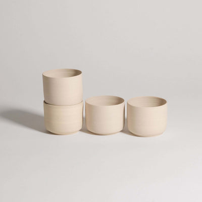 Set of 4 Nomi Creme coffee cups in grey stoneware with glossy glaze interior and raw exterior finish.