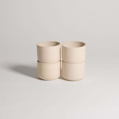 Set of 4 Nomi Creme coffee cups in grey stoneware with glossy interior glaze and raw exterior.