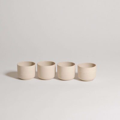 Set of 4 Nomi Creme espresso cups in grey stoneware with glossy glaze interior and raw exterior.