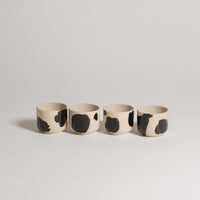 Set of 4 Nomi Pepe espresso cups in grey stoneware with glossy black hand-painted accents.