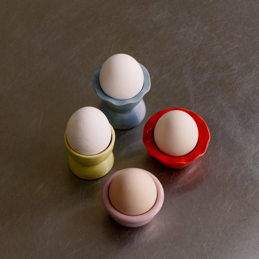 4er Set - handgemachtes Eierbecher Set aus Steinzeug in gemischten Farben mit Eiern.
