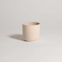 Stoneware tea cup in Nomi Creme, featuring a raw exterior and glossy interior, ideal for enjoying your favorite beverages.