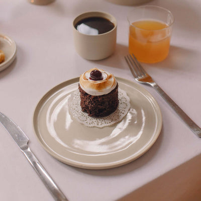 Set of 8 – Breakfast Plate – Creme mit Schokoladenkuchen und Getränken auf einem gedeckten Tisch.