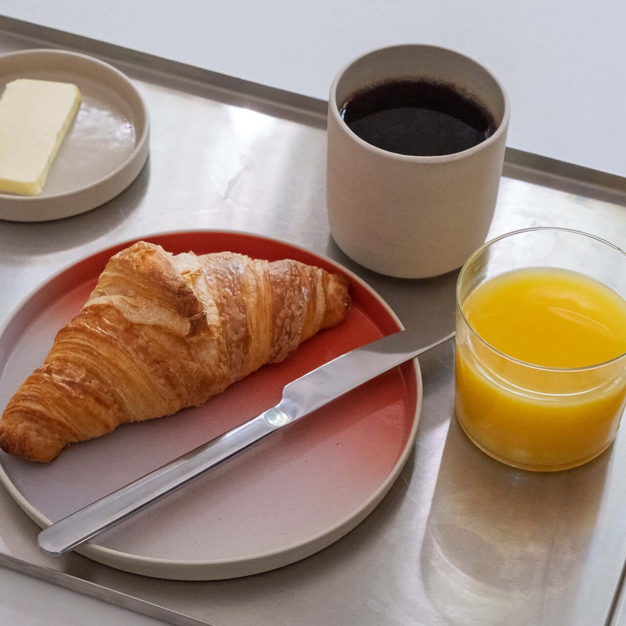 Set of 8 - Breakfast Plate – New Dawn mit Croissant, Kaffee und Orangensaft auf einem Tablett.