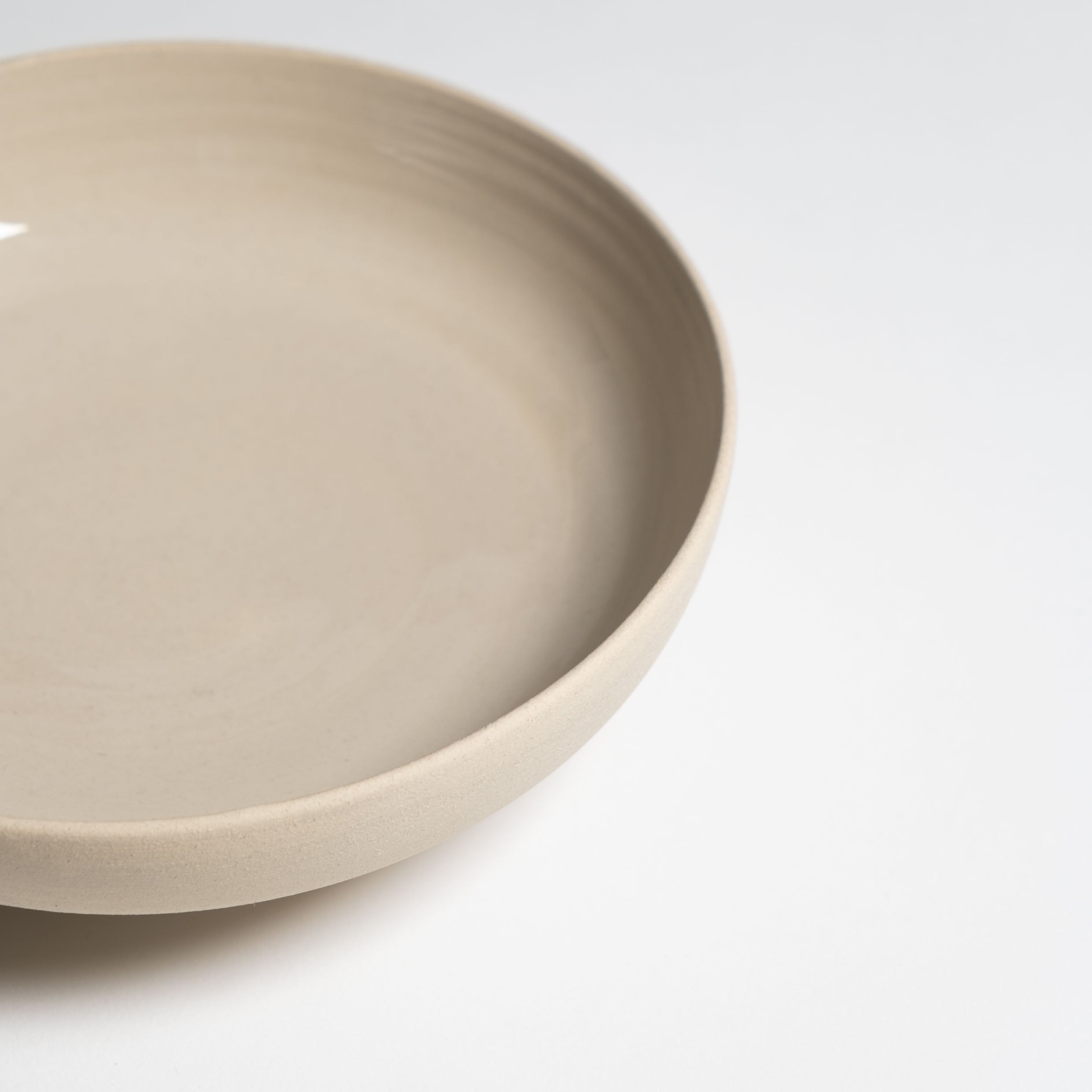 Pedestal Bowl Aleah Creme aus Steinzeug mit glänzender Glasur und fußbasiertem Design.