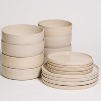 Creme tableware set 16 pieces stacked including breakfast bowls and dinner plates in a modern design.