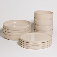 Creme tableware set 12 pieces including bowls and plates, made of grey stoneware clay with a glossy glaze.